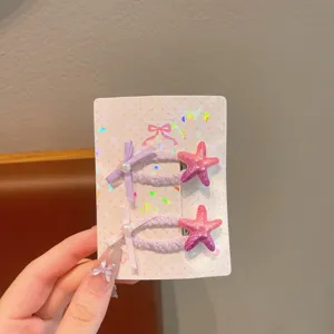 Detailed view of cute children hair clips with pink starfish and bows, sweet hair accessories.