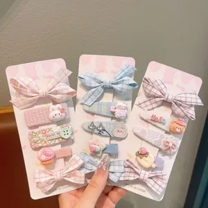 Detailed close-up of sweet pink bow hair clips and cute cartoon pins set for girls daily.