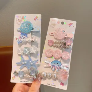 Close-up detail of cute ocean-themed hair clips featuring shells, starfish, and pearls.
