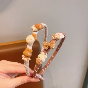Cute children's fabric hairband with adorable resin bear and bow charms, anti-slip design for girls.