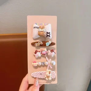 Cute cartoon hair clip set detail showing sweet rabbit and bow designs on a pink card.