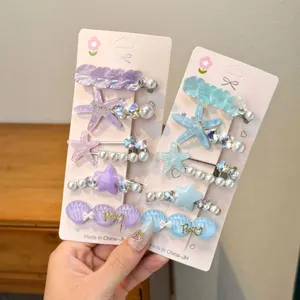 Detailed shot of colorful children hair clips with starfish and seashell designs, pearl and rhinestones.