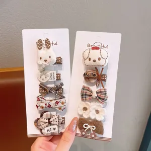 Vue détaillée de pinces à cheveux à carreaux avec adorables lapins et nœuds tricotés.