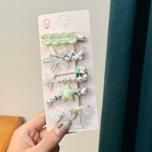 Children's marine theme hair clip set, detail shot showing starfish and shell designs on backing card.