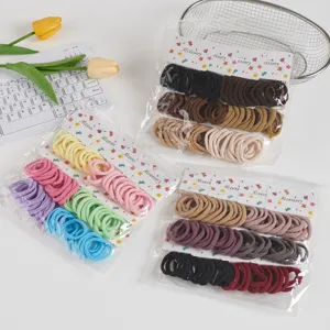 Detailed view of elastic seamless hair ties in various colors, set on cards inside clear bags.