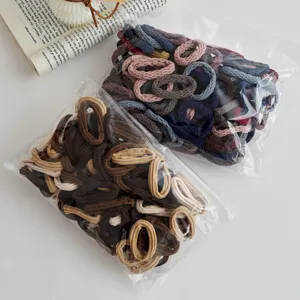 Close-up detail of colorful elastic hair ties in clear bags, showcasing rich tones.