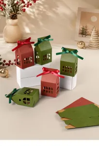 Christmas house shaped gift box detail view, showing cutout windows, ribbons and flat paper.