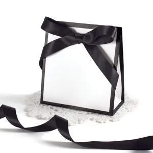 Minimalist black and white gift bag featuring an elegant silk bow for party favors.