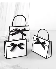Minimalist black and white gift bags with chic black ribbon bows, perfect for high-end gifting.