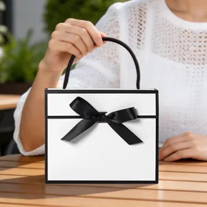 Minimalist black and white folding gift box with elegant ribbon bow for party favors.