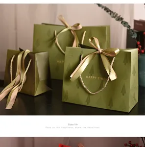 Gruene Weihnachtstüten mit goldenen Schleifen, Tannenzweig Muster und edlem Geschenkpapier.