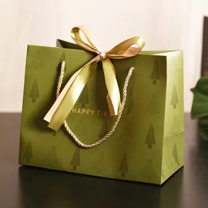 Retro grüne Geschenktüte mit Tannenmuster und eleganter goldener Schleife für Feste.