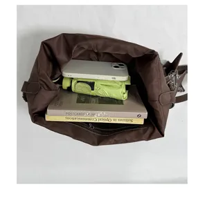 Detailansicht des braunen Tascheninneren mit Stauraum für alltägliche Dinge und Bücher.