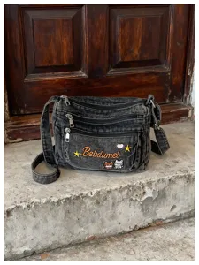 Multi-compartment denim crossbody bag with cute cat embroidery and retro washed finish.