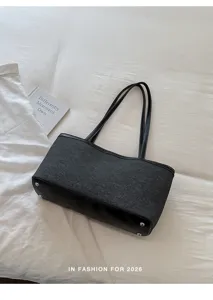 Vue détaillée du sac fourre-tout noir avec fond en cuir, clous en métal et fines bretelles.