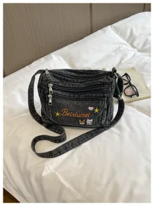 Black denim multi-compartment crossbody bag with cute cat embroidery and zipper pockets.