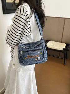 Stylish denim crossbody bag with cute cat embroidery, multi-layer pockets for women daily wear.
