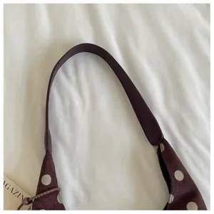 Detailed view of stylish brown polka dot shoulder bag strap, minimalist casual design.