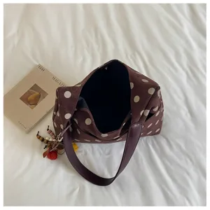 Brown polka dot shoulder bag detail view, casual suede hobo handbag showing texture and strap.
