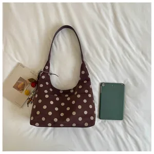 Detailed view of the stylish polka dot shoulder bag with soft suede texture and front pocket.