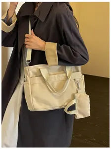 Sac bandoulière en toile décontracté vue détaillée, design multi-poches avec petite pochette.