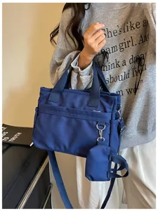 Vue détaillée du sac bandoulière décontracté en toile bleue avec poignées et mini-pochette.