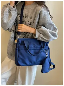 Vue détaillée du sac bandoulière décontracté en toile bleue avec poches et petite pochette.