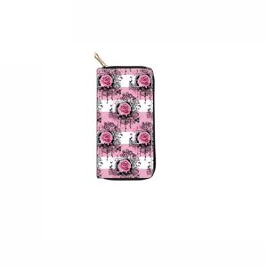 Détail du long portefeuille zippé avec motif de roses roses et rayures sur fond noir et blanc.