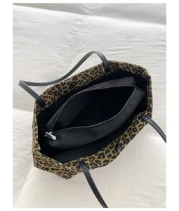 Leopard print canvas tote bag detail, featuring black shoulder straps and a handy inner pouch.