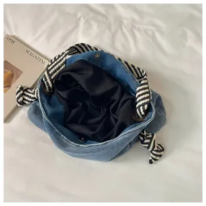 Borsa a tracolla in denim con manici a righe bianche e nere e ampio scomparto interno.