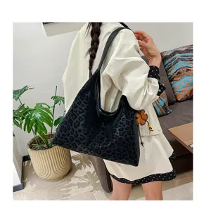 Detailaufnahme einer stilvollen schwarzen Leo-Print Schultertasche im Innenbereich.