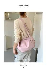 Roze suède retro schoudertas met metalen klinknagels en sterrenhangertje voor dames.