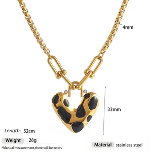Stainless steel heart pendant necklace with gold paperclip chain and black enamel details.