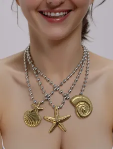 Primo piano della collana di catene di perle argentate multistrato con ciondoli conchiglia e stella.