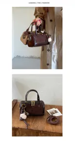 Primer plano detalle del bolso de mano de cuero ante marrón con cremallera y colgante.