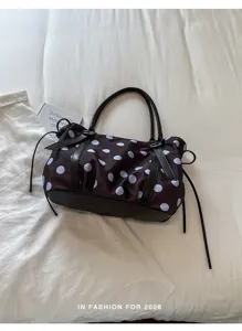 Detailed view of the trendy polka dot nylon tote bag with pleated design and handles.