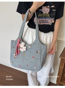 Schoener gestreifter Canvas Shopper mit Stickerei und Pluesch Anhaenger fuer den Alltag.
