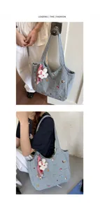 Detailansicht der gestreiften Canvas-Tasche mit süßer Stickerei und Plüsch-Hasenanhänger.