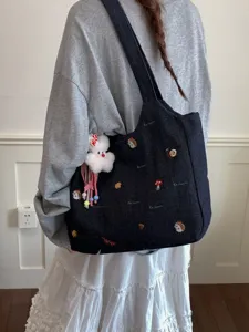 Lässige dunkle Jeans-Shopper-Tasche mit süßer Stickerei und flauschigem Anhänger, groß.