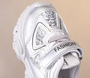 Children silver sparkly sneakers close up toe design and convenient velcro strap detail.