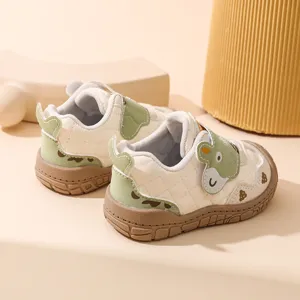 Vue détaillée de chaussures de marche bébé, baskets souples avec patch animal vert.
