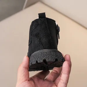 Children black ankle boots detail view showing textured sole, side zipper and heel pull tab.