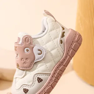 Vue détaillée de chaussures bébé, tige beige matelassée douce avec semelle patch dessin animé.