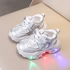 Detailed view of stylish kids light-up sneakers featuring silver glitter and mesh finish.