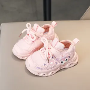 Close-up of pink toddler light-up sneakers with cute cartoon and breathable soft sole.