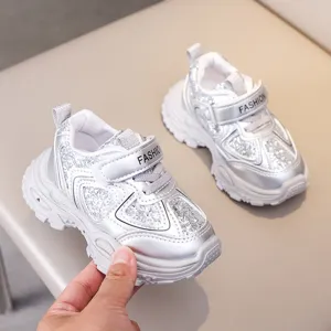 Detailed shot of kids silver glitter sneakers, casual toddler walking shoes with velcro.