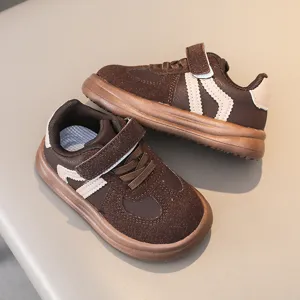 Brown kids sneakers detail showing textured suede panels, double velcro and thick anti-slip sole.