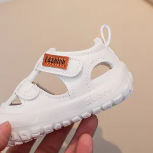 White baby summer sandals with hollow-out design, hook and loop strap, and soft anti-slip sole.