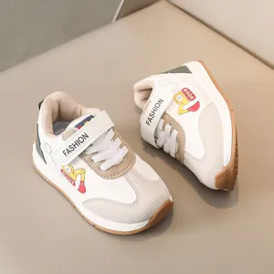 Λεπτομερής όψη παιδικών δερμάτινων sneaker με μοτίβο εκσκαφέα και κούμπωμα με σκρατς.