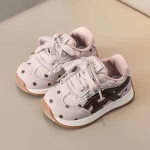 Belles baskets pour tout-petits en automne, chaussures bébé roses avec pois et semelle.
